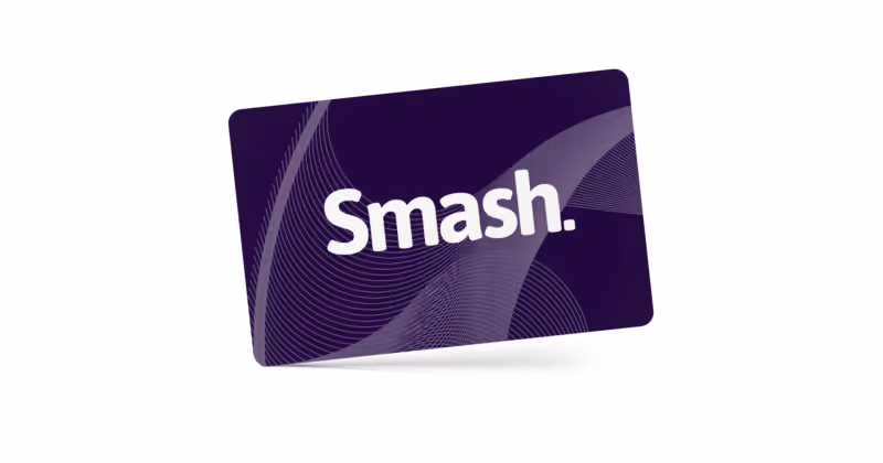Cartão presente roxo-escuro inclinado sobre fundo branco, com a marca Smash em branco e linhas curvas ao fundo