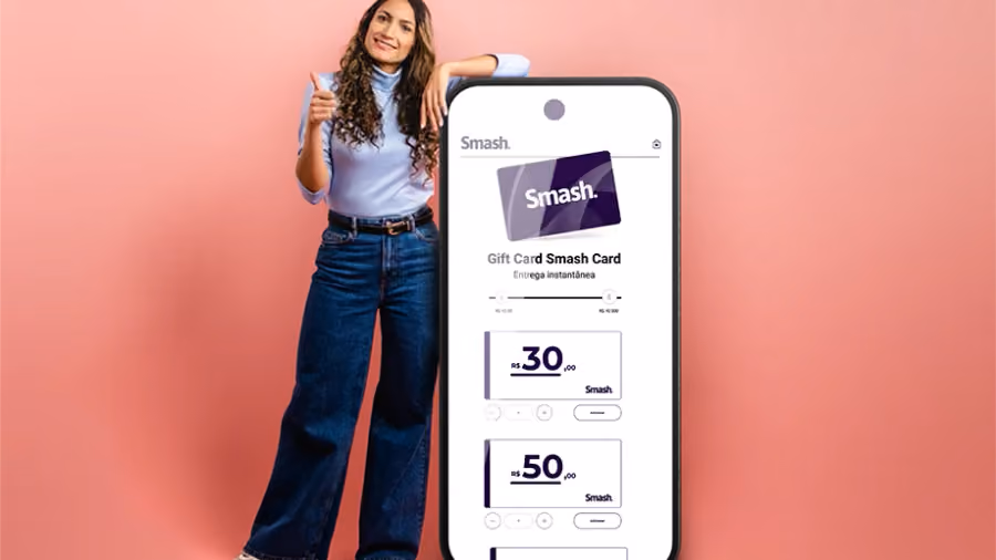 Foto de mulher com o polegar erguido apoiada em um celular gigante que exibe a página de compra do Smash Card, em fundo rosa